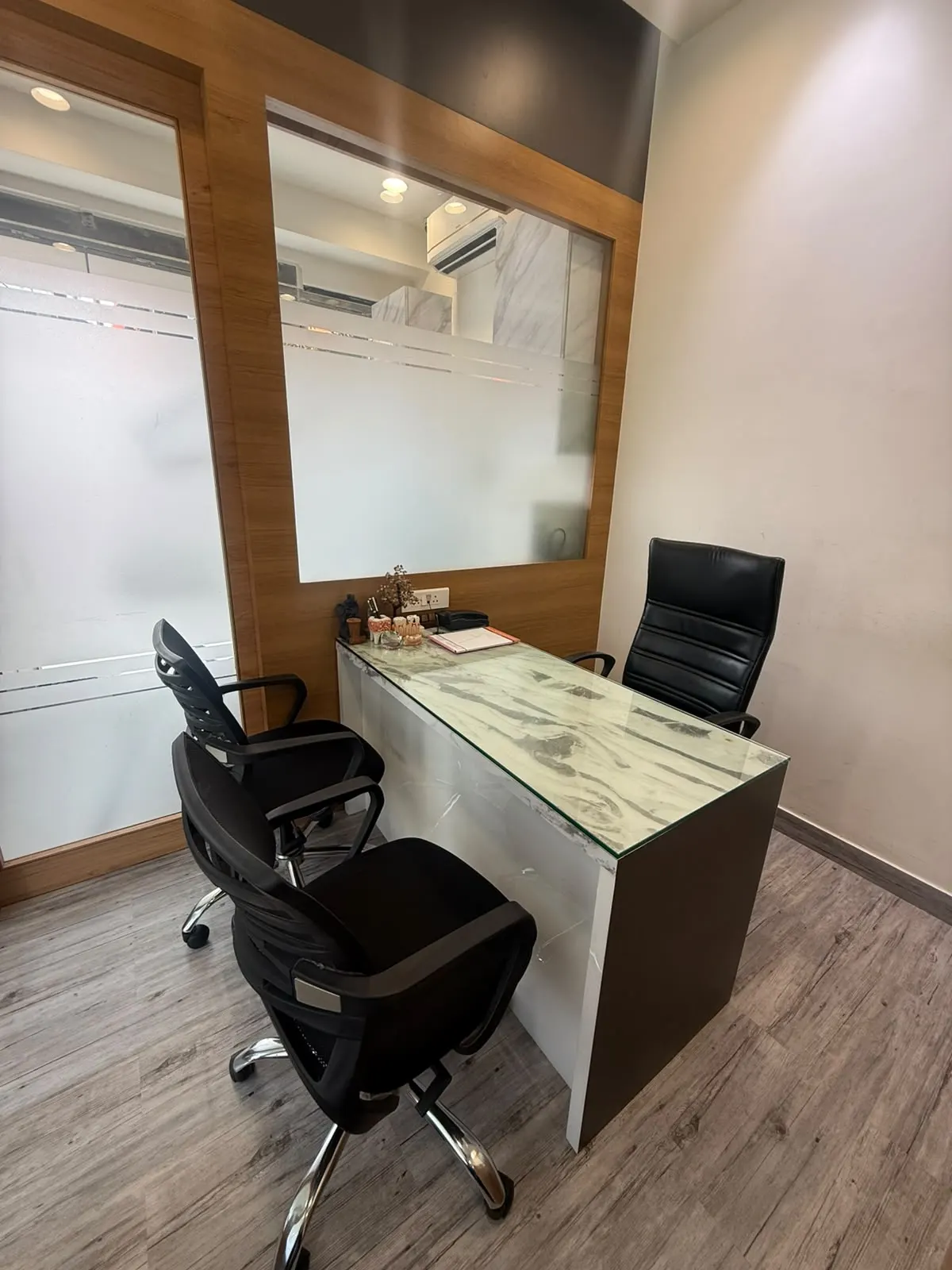 A consultation desk with a marble top and chairs for patient and family
