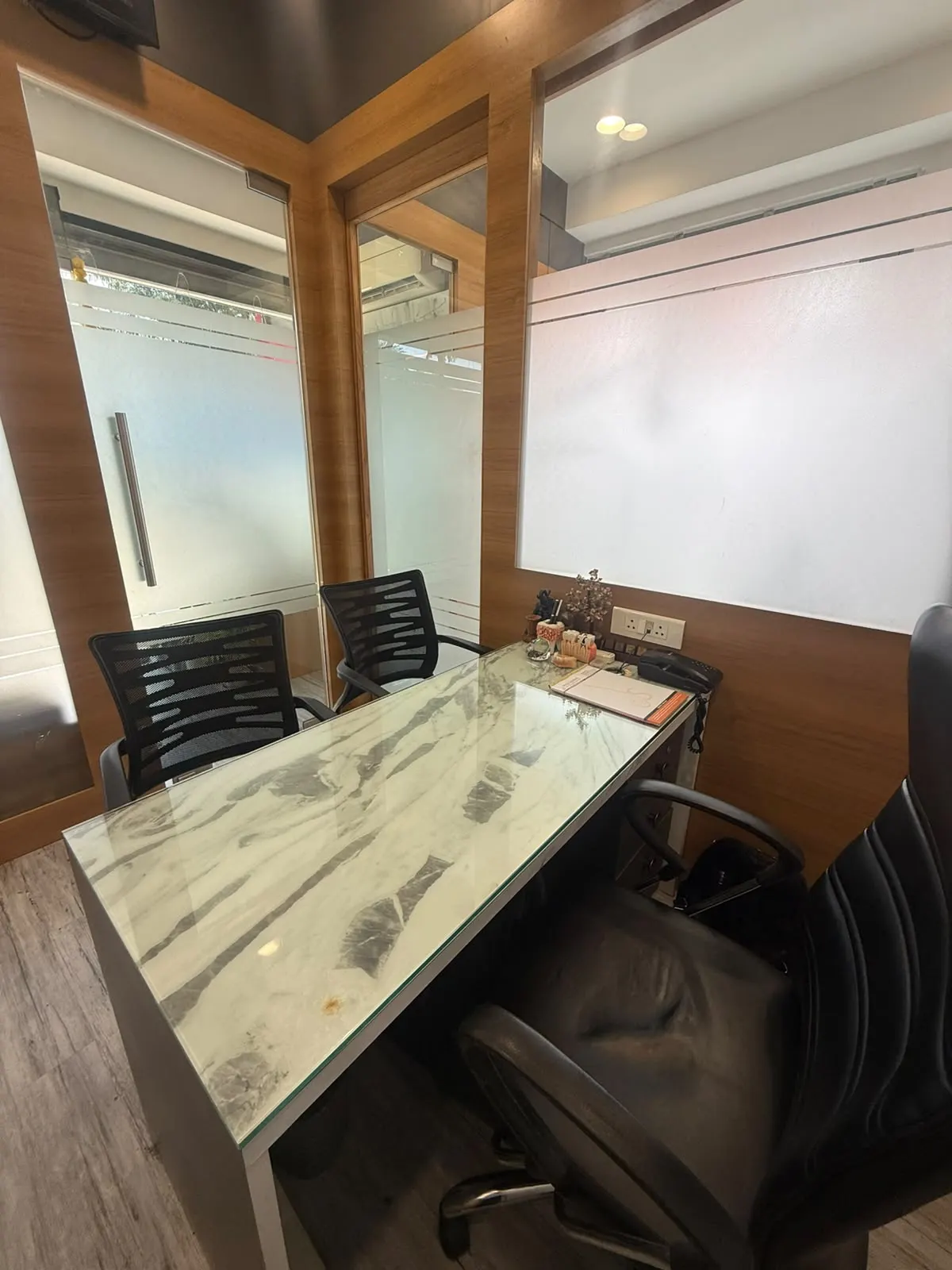 The consultation room with glass partitions and wood panelling