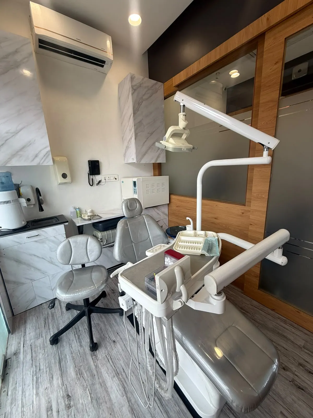 A second treatment room with marble-finish cabinets and an autoclave