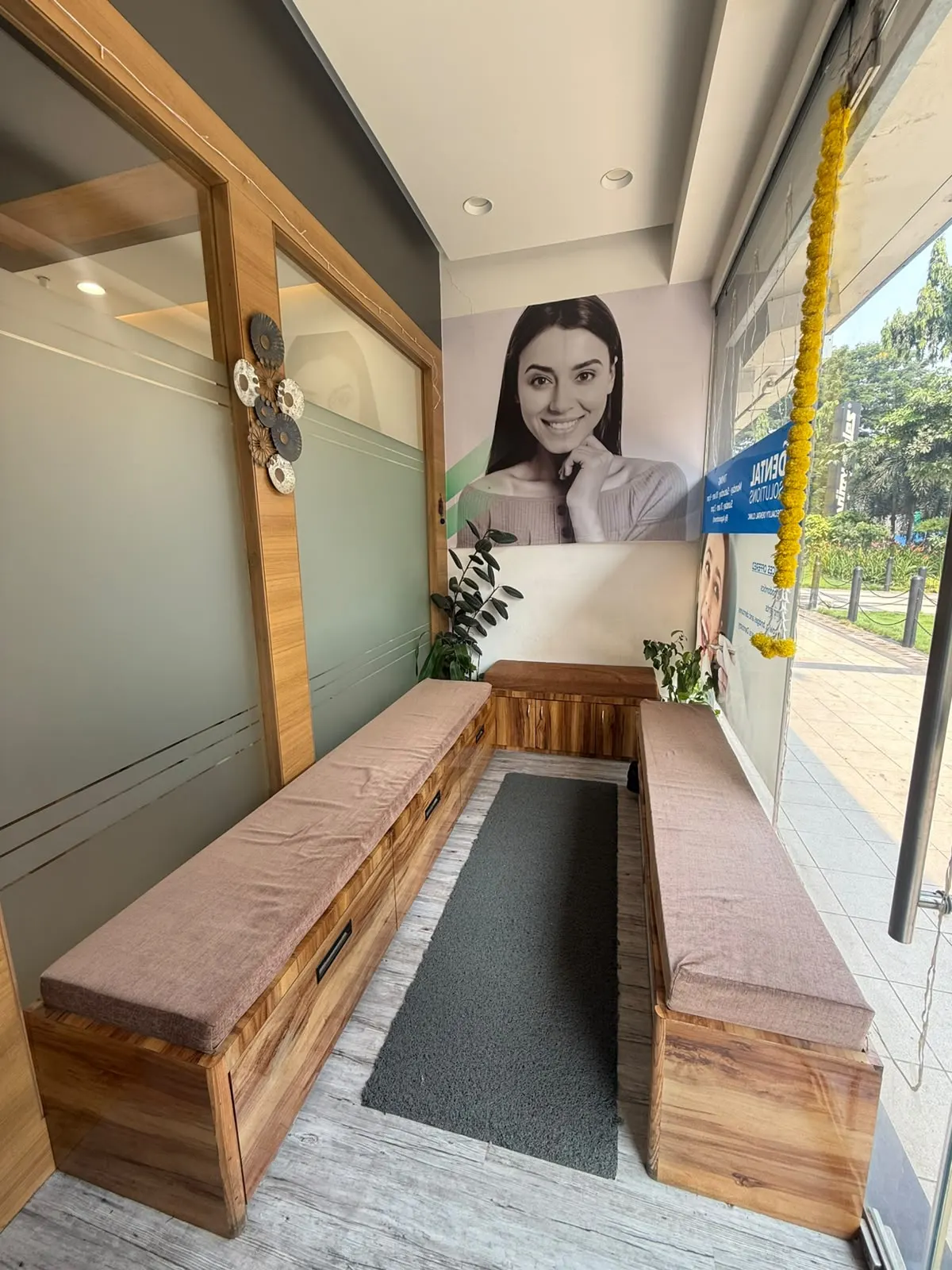 Wooden bench seating with cushions in the clinic waiting area, beside a glass shopfront